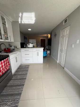 a kitchen with granite countertop a sink cabinets and stainless steel appliances
