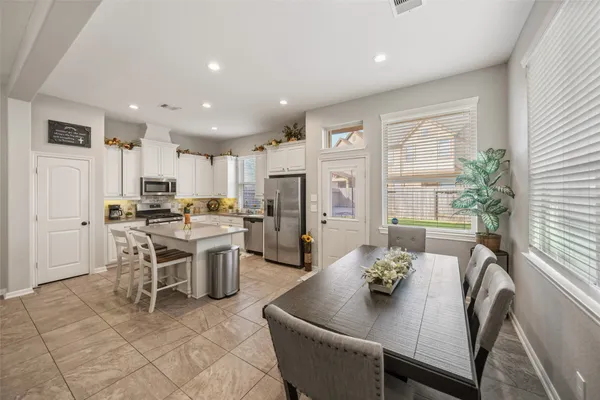 a dining room with furniture a large window and stainless steel appliances