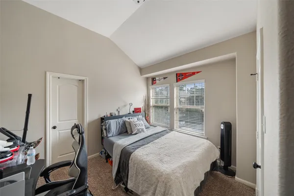 a bedroom with a bed and a flat tv screen next to a window