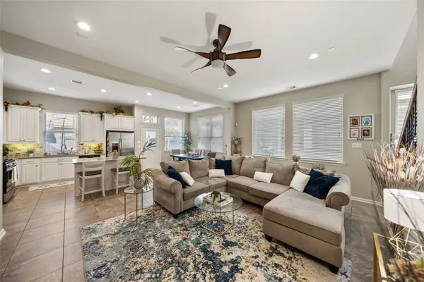 a living room with furniture kitchen view and a large window