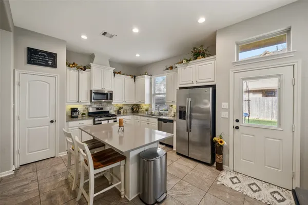 a kitchen with stainless steel appliances a refrigerator stove microwave and cabinets