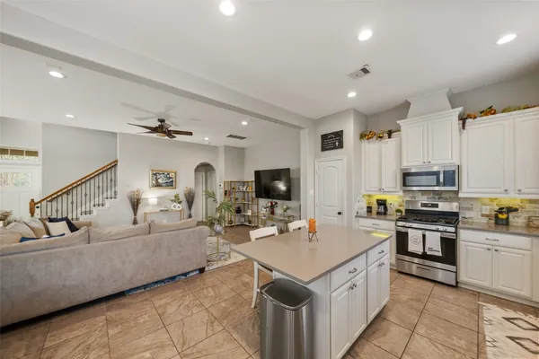 a large kitchen with stainless steel appliances lots of counter space and a sink