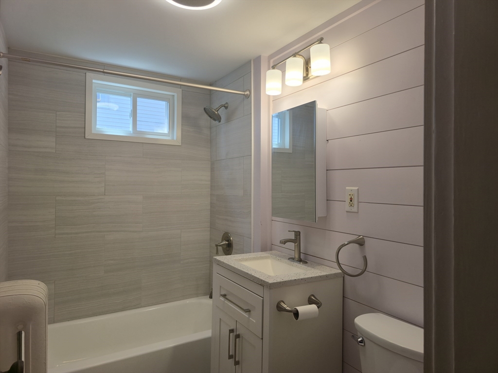 105 Fuller Street, Unit 1 Boston, MA 02124 - Photo 4 of 6 a bathroom with a granite countertop sink toilet and shower