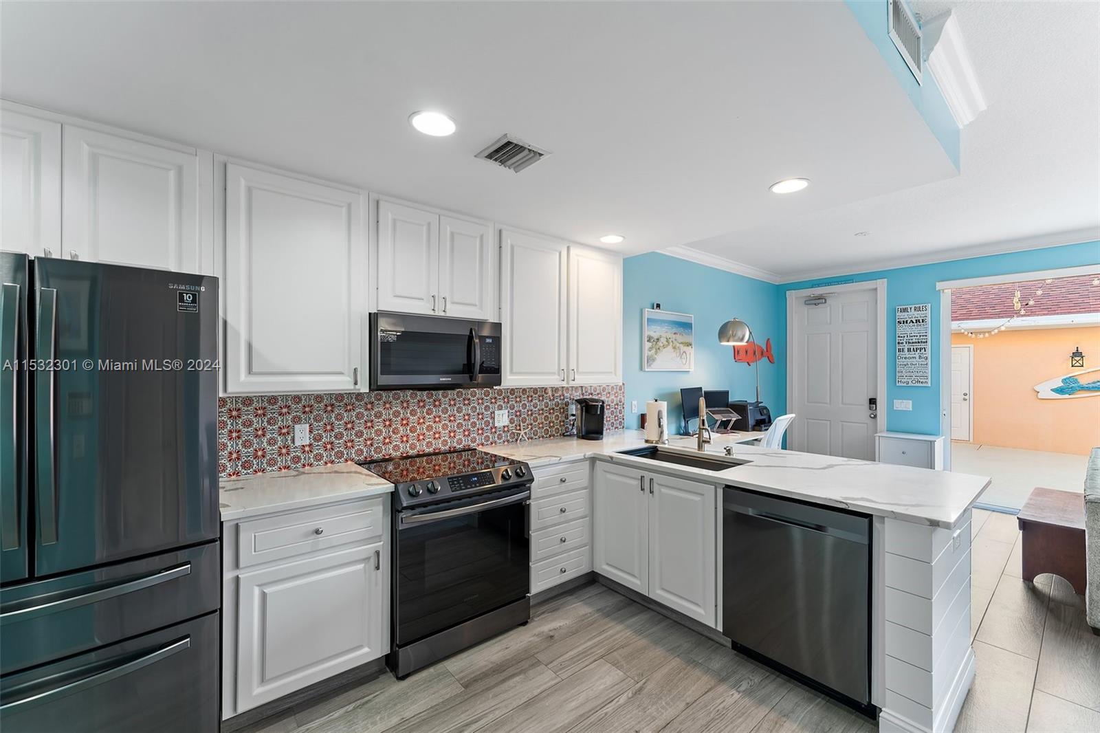 136 Milbridge Drive Jupiter, FL 33458 - Photo 15 of 50 a kitchen with granite countertop stainless steel appliances and wooden cabinets