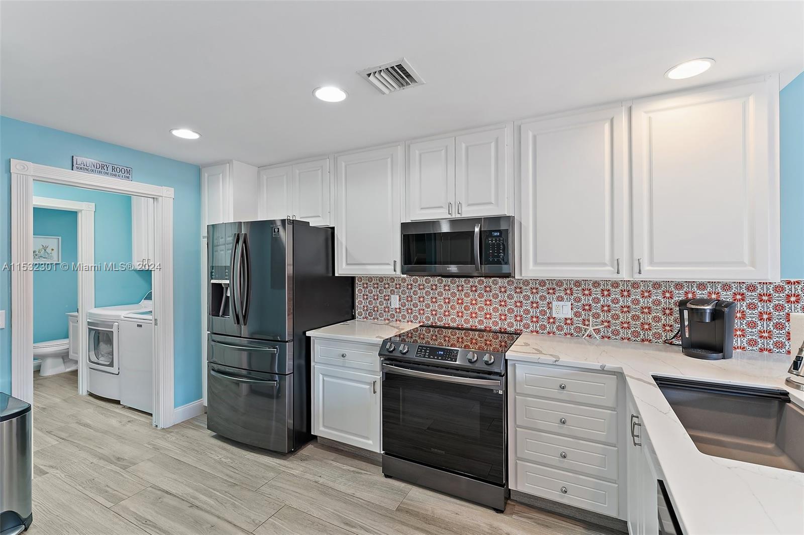 136 Milbridge Drive Jupiter, FL 33458 - Photo 17 of 50 a kitchen with a refrigerator stove and sink