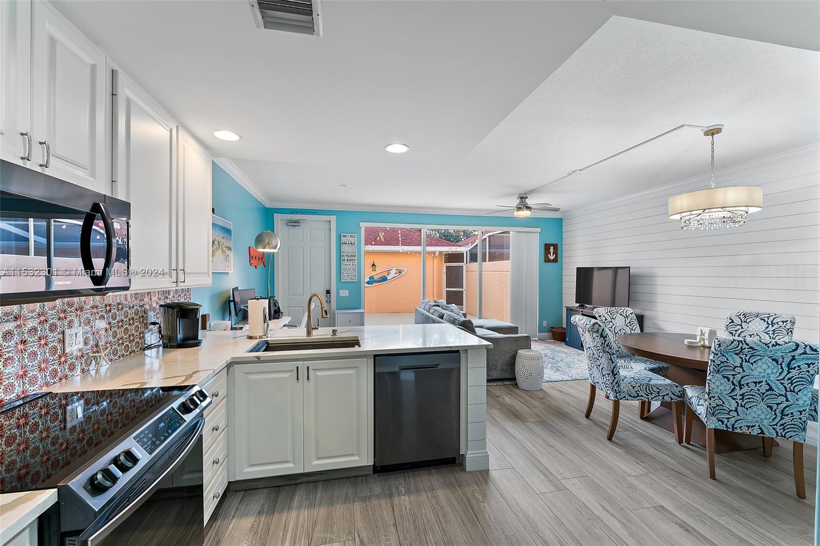 136 Milbridge Drive Jupiter, FL 33458 - Photo 18 of 50 a kitchen with stainless steel appliances a sink dishwasher stove refrigerator dining table and chairs