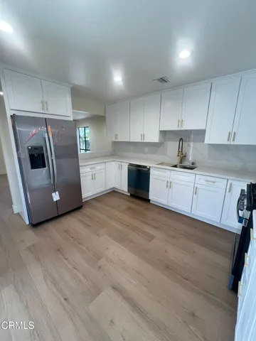 a kitchen with granite countertop white cabinets and stainless steel appliances