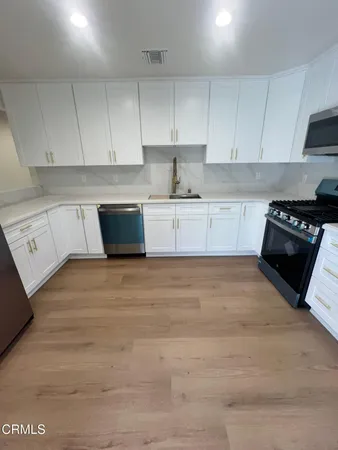 a kitchen with granite countertop white cabinets and black appliances