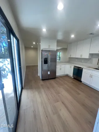 a large kitchen with a wooden floor and large window