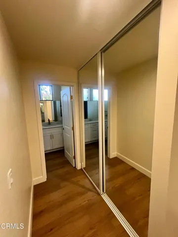 a view of a hallway with a dining room and wooden floor