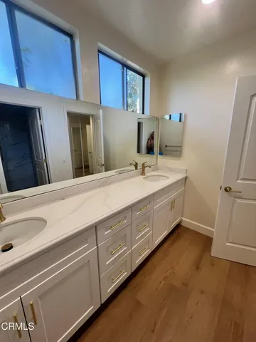 a spacious bathroom with a double vanity sink and mirror