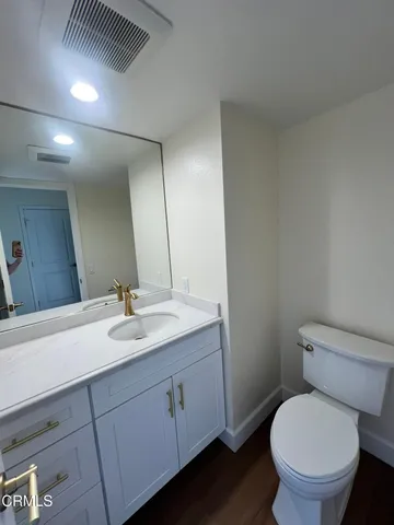 a bathroom with a granite countertop toilet sink and mirror