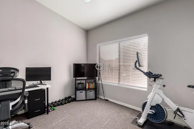 a view of a workspace with furniture and a window