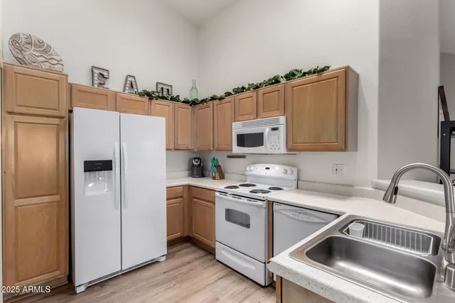 a kitchen with a refrigerator sink and white cabinets