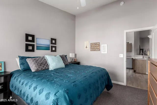 a bedroom with a large bed and a view of kitchen