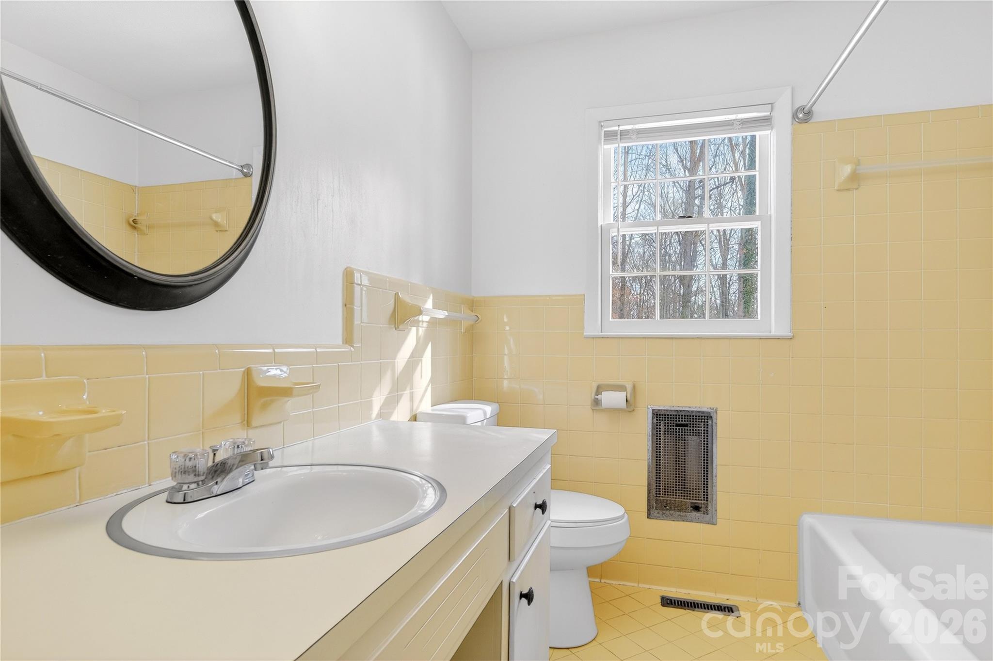 852 Fieldstone Road Mooresville, NC 28115 - Photo 24 of 34 a bathroom with a sink a mirror a toilet and a window