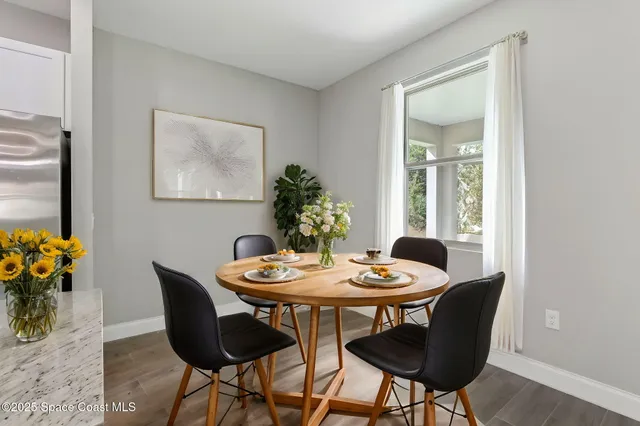 a spacious bedroom with a large bed a chandelier and a potted plant
