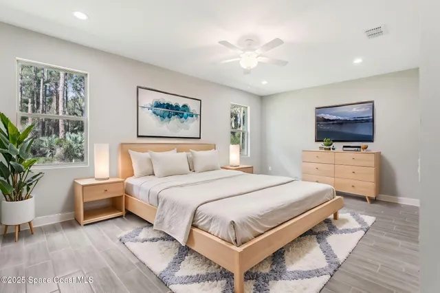 a bedroom with a bed and a potted plant