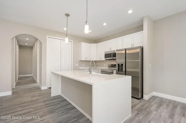 a kitchen with kitchen island a sink stainless steel appliances and cabinets