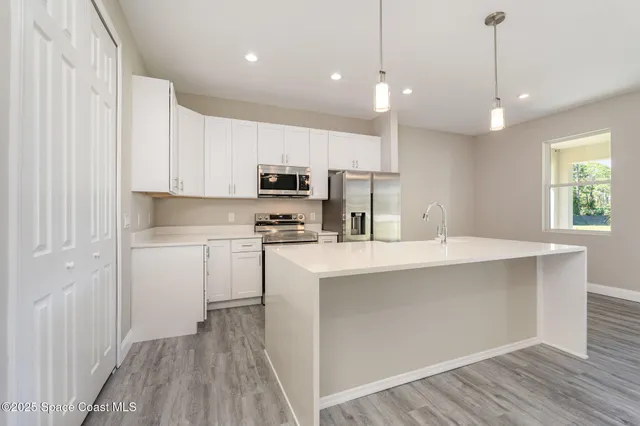 a view of kitchen with wooden floor and electronic appliances