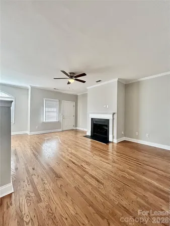 a view of empty room with wooden floor and fireplace