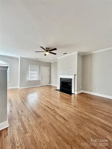 a view of empty room with wooden floor and fireplace