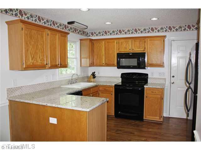4203 Beacon Ridge Drive High Point, NC 27265 - Photo 3 of 16 Kitchen. New Granite counter tops, tile back splash, faucet, dishwasher, microwave and floor!