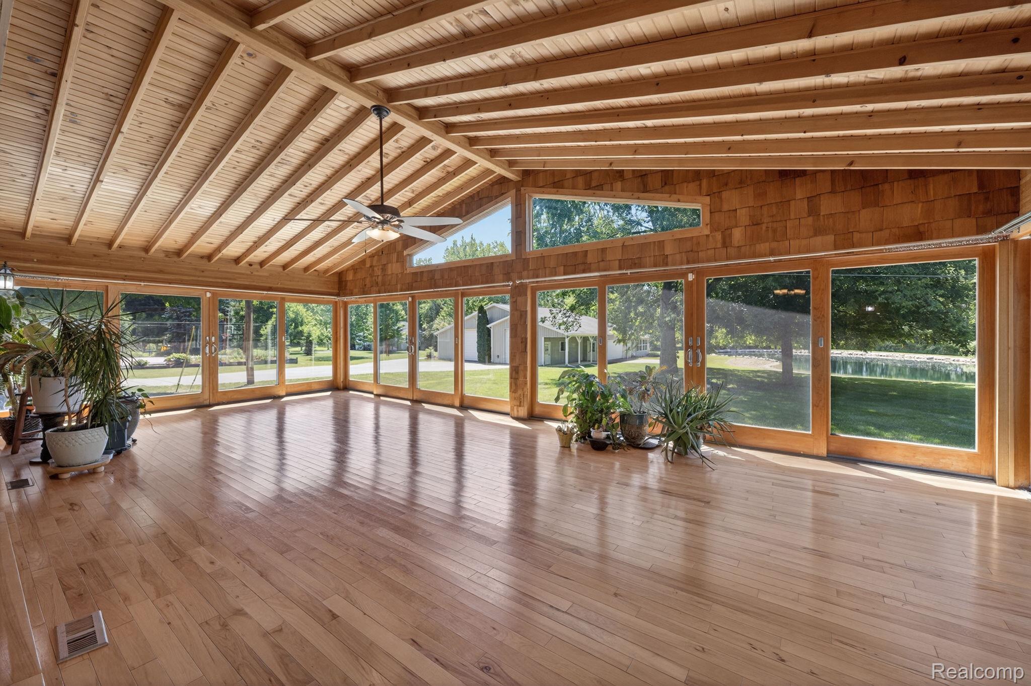 9353 Hill Road Swartz Creek, MI 48473 - Photo 34 of 98 Spacious sunroom featuring extensive wood-finish flooring, a vaulted wood-paneled ceiling, and a ceiling fan