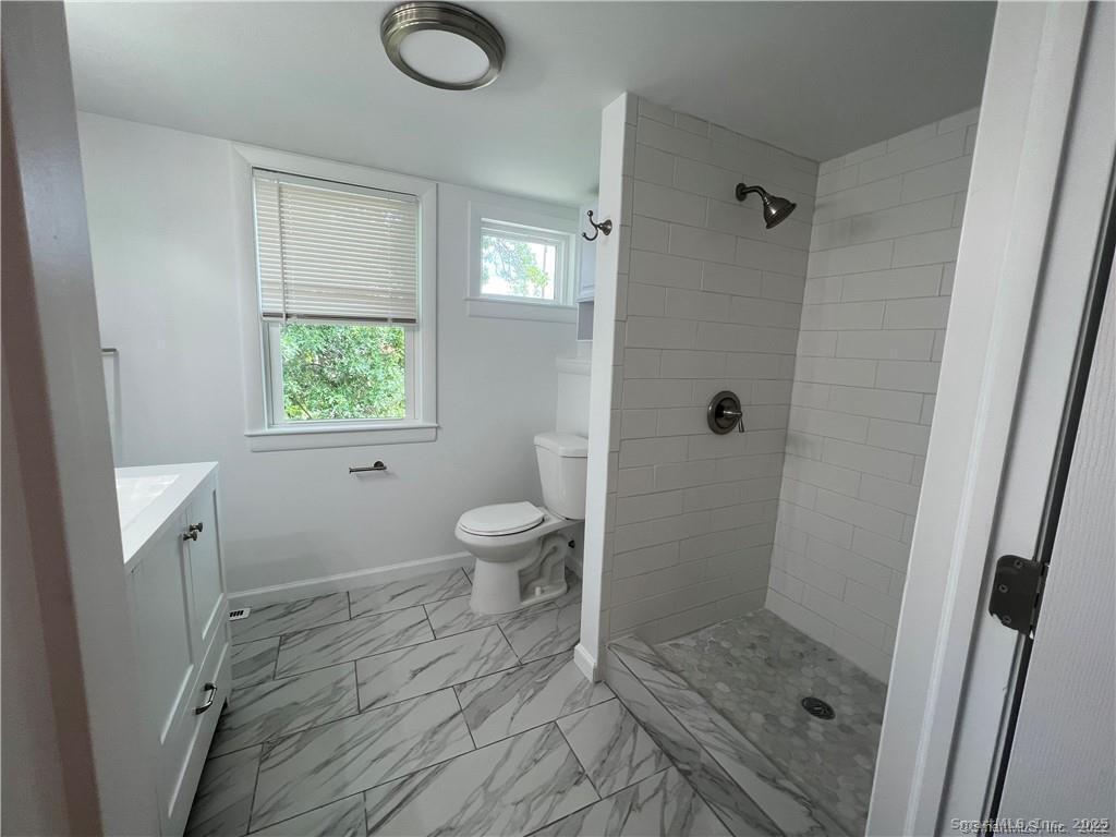 144 Rakoczy Avenue Fairfield, CT 06824 - Photo 12 of 19 a bathroom with a granite countertop sink a toilet and shower