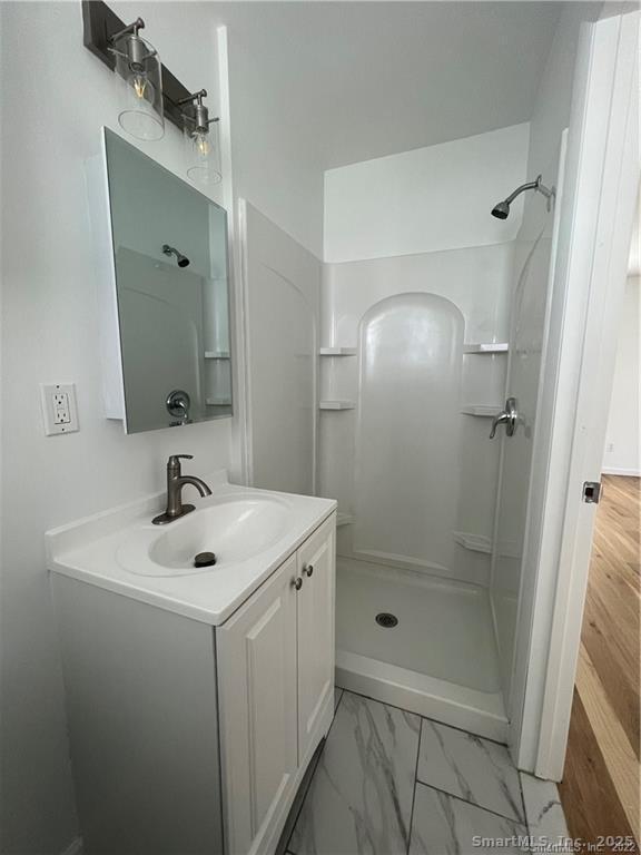 144 Rakoczy Avenue Fairfield, CT 06824 - Photo 16 of 19 a bathroom with a sink a mirror and shower