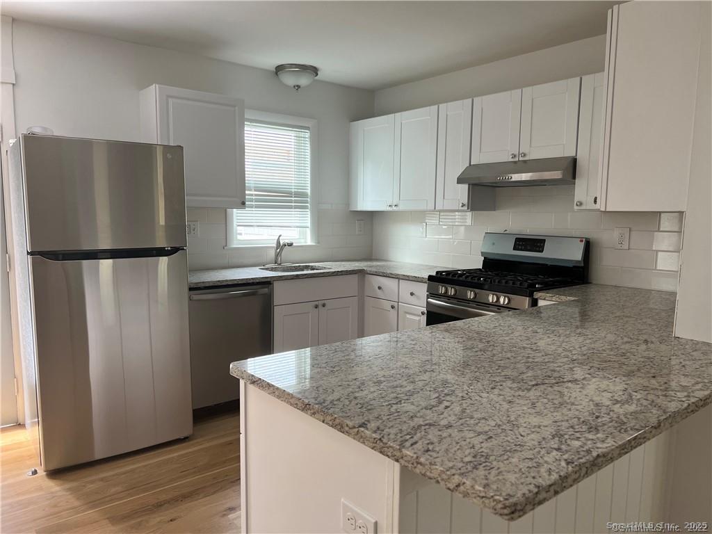 144 Rakoczy Avenue Fairfield, CT 06824 - Photo 4 of 19 a kitchen with granite countertop a sink stove and refrigerator