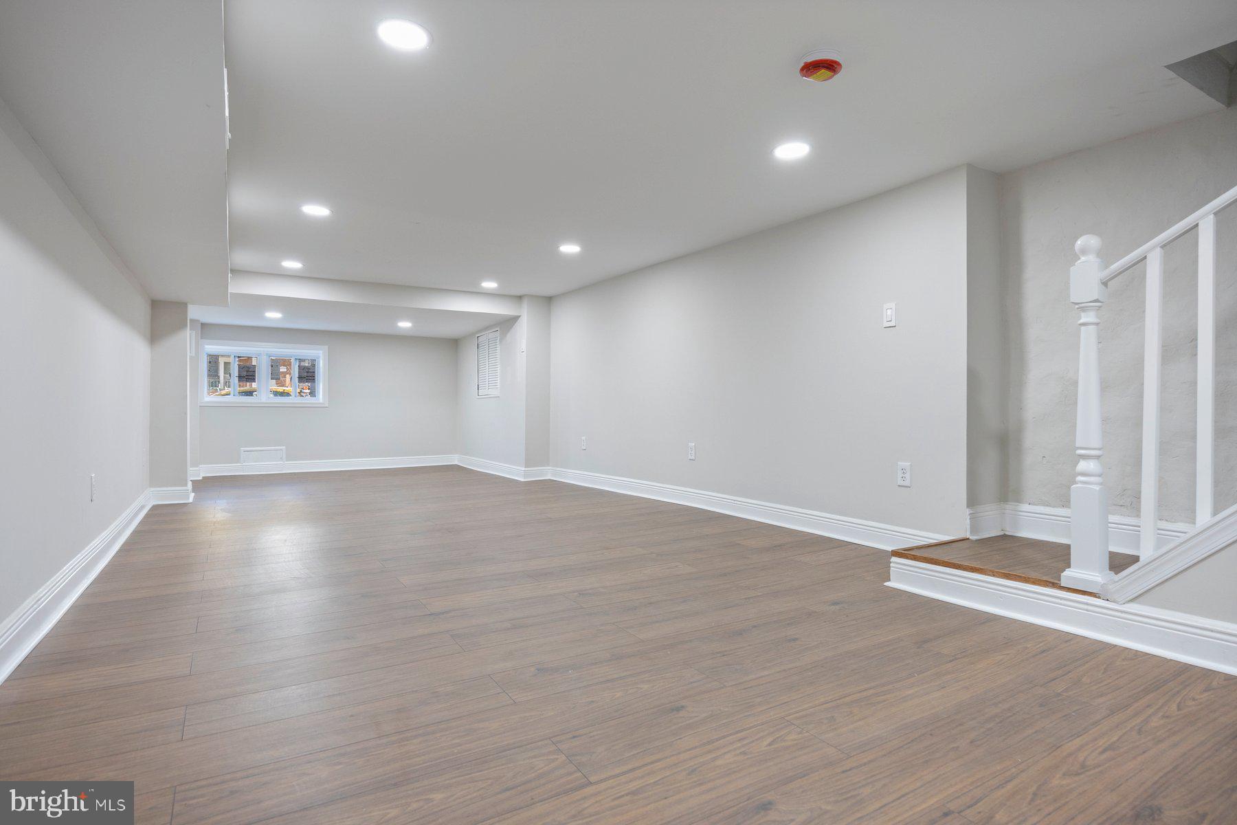 117 Collins Avenue Baltimore, MD 21229 - Photo 23 of 27 an empty room with wooden floor and windows