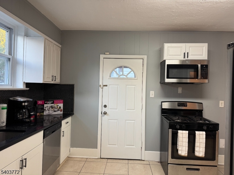 351 Ogden Street Orange, NJ 07050 - Photo 6 of 13 a kitchen with stainless steel appliances a stove microwave and cabinets