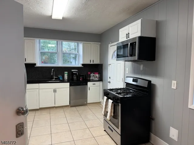 a kitchen with stainless steel appliances granite countertop a stove and a microwave