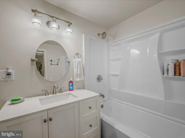 a bathroom with a tub sink and mirror