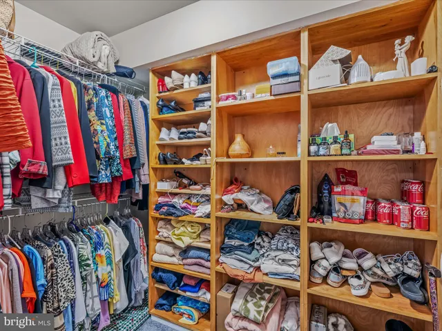 a view of walk in closet with clothes and shoes