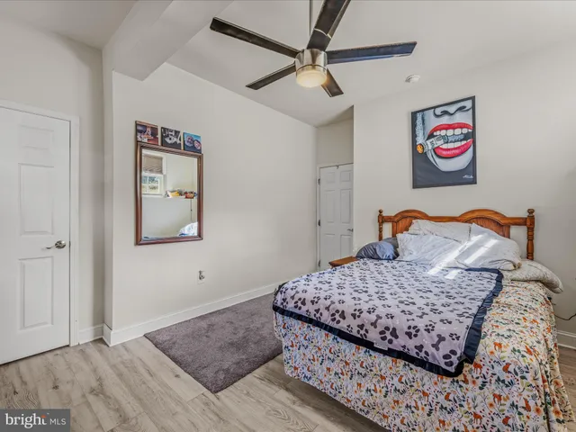 a bedroom with a bed and painting on the wall