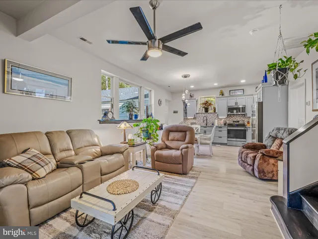 a living room with furniture a ceiling fan and a rug