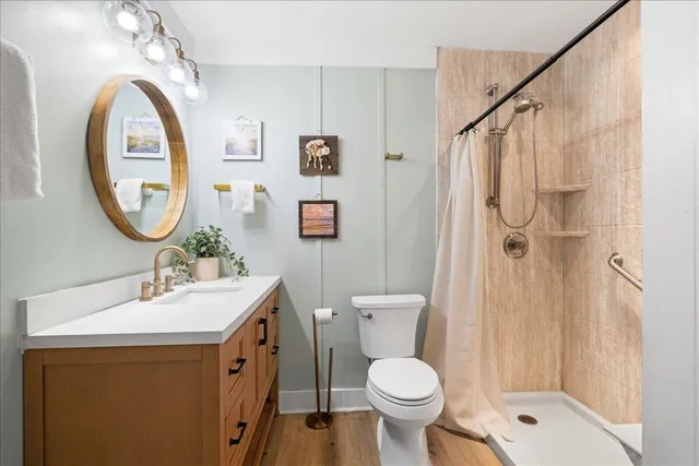 a bathroom with a sink a toilet and shower
