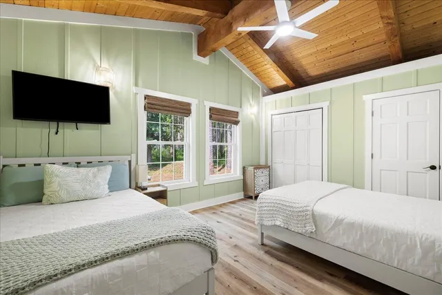 a bedroom with a large bed and a flat screen tv