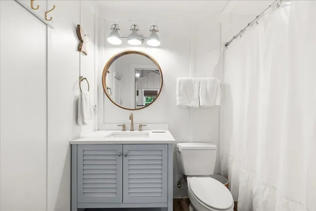 a bathroom with a sink a mirror a toilet and a mirror