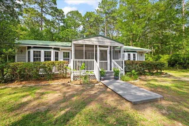 a view of a house with backyard and sitting area