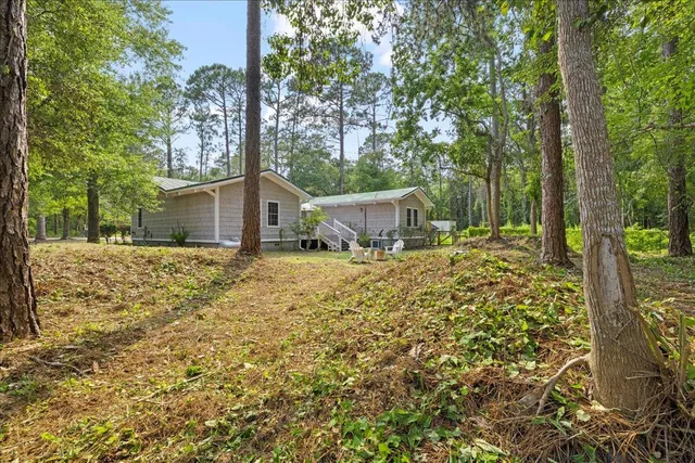 a view of house with backyard and trees