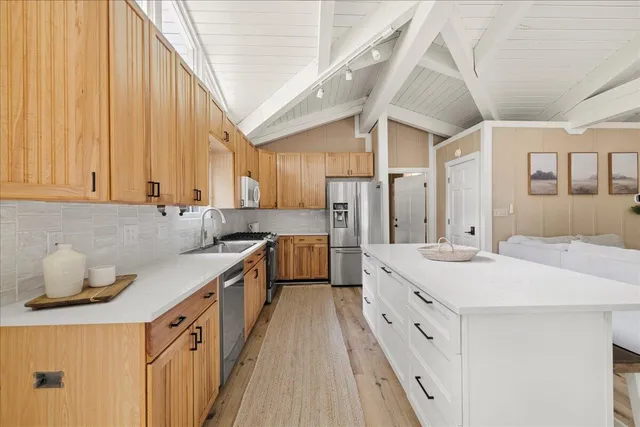 a large white kitchen with a large window