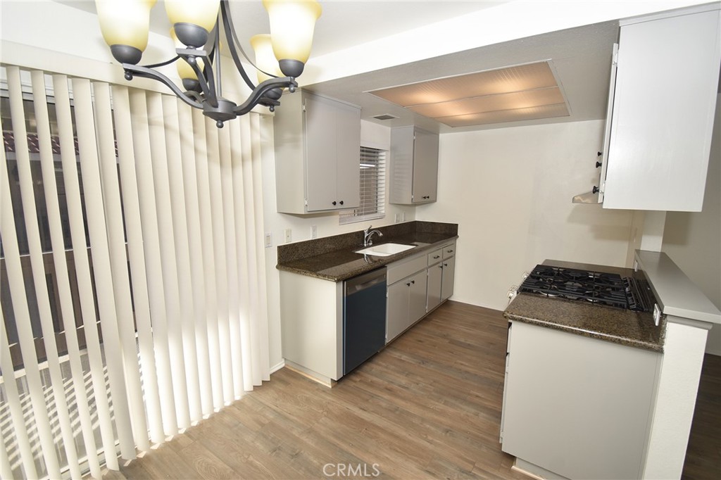 a kitchen with granite countertop a stove a sink and a refrigerator