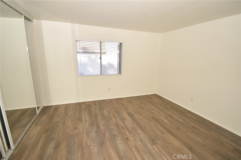 9872 Highland Avenue, Unit B Rancho Cucamonga, CA 91737 - Photo 11 of 16 an empty room with wooden floor and windows