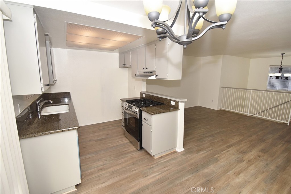 9872 Highland Avenue, Unit B Rancho Cucamonga, CA 91737 - Photo 7 of 16 a kitchen with stainless steel appliances granite countertop a sink a stove and a wooden floor