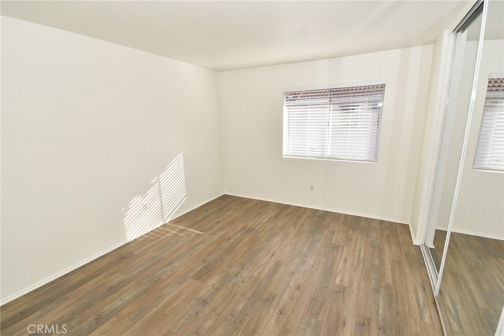 9872 Highland Avenue, Unit B Rancho Cucamonga, CA 91737 - Photo 8 of 16 an empty room with wooden floor and windows