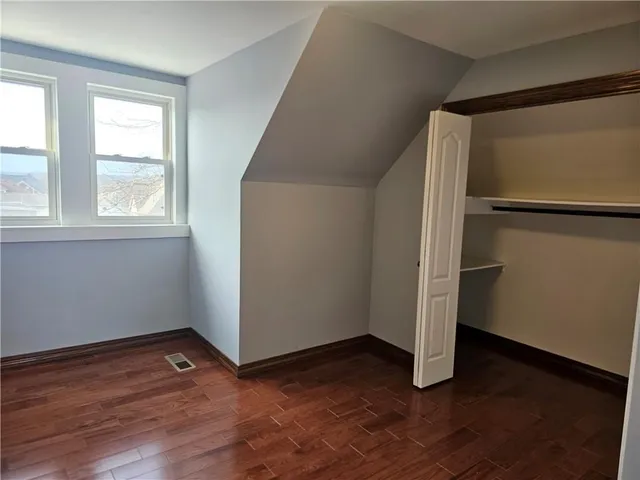 an empty room with wooden floor and window