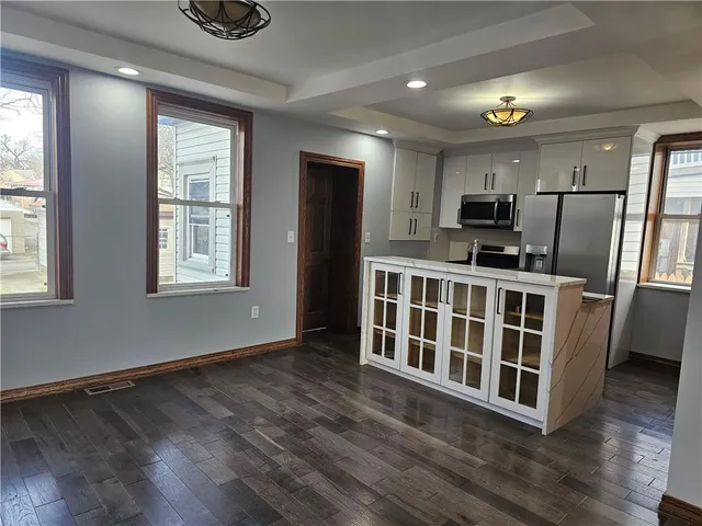 a kitchen that has a lot of cabinets a sink and appliances in it